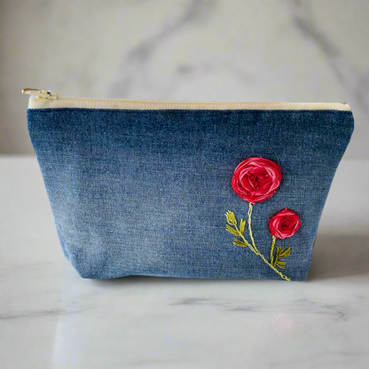 Upcycled denim makeup bag with handmade embroidered flower